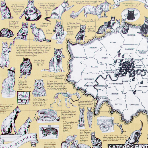 Detail of a cream tea towel with various illustrations of cats over a map of London.