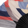 Detail of a hand fan with a black frame and a geometric pattern in red, blue and cream colours.