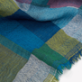 Detail of a wool scarf with a blue and green check pattern.