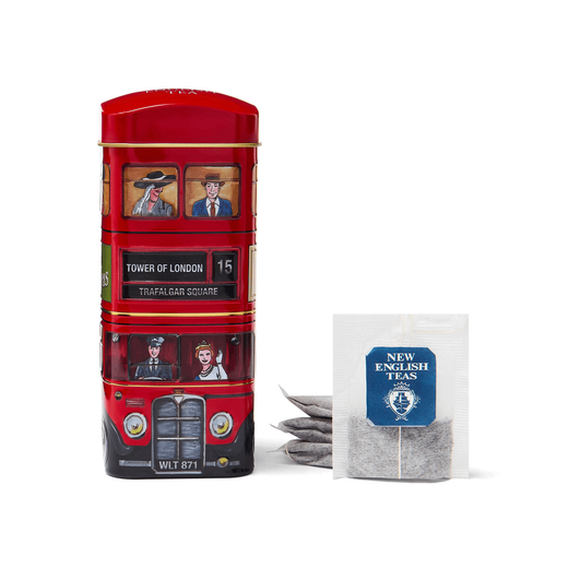 Tin tea caddy modelled on a London bus. Five tea bags of black tea are arranged next to it.