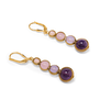 A pair of drop earrings featuring round beads in a gradient of pink and purple shades photographed on a white background.