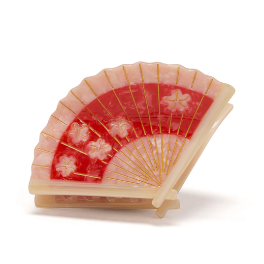 Hair clip in the shape of a red and pink paper hand fan. 