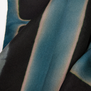 A detail of a scarf dyed with a black and blue motif.