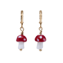 A pair of earrings, each with a red and white mushroom pendant.