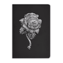 The cover of this black, lined notebook features a rose-shaped brooch of layered diamonds, by Cartier