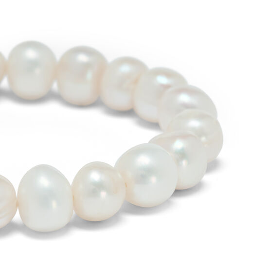 A close up showing details of the white pearls that make up the bracelet.
