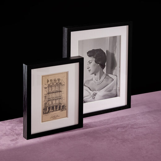 Two framed print reproducing an etched illustration of Cartier's London flagship store and a black and white photograph of Princess Margaret.