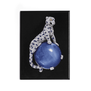 A black rectangular magnet featuring a diamond brooch designed to look like a panther seated on a spherical sapphire