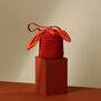 Summer bucket bag, styled on a terracotta coloured plinth.