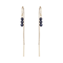 A pair of pull through earrings with a gold chain and three round blue stones.