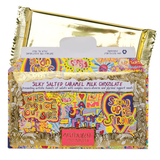Silky salted caramel milk chocolate by ARTHOUSE Unlimited. The gold paper wrapping is open to reveal a gold foiled packagin containing the chocolate bar.