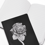 The notebook shown open reveals broad lined pages 