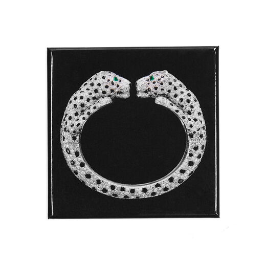 A square black magnet featuring Cartier's twin-headed diamond panther bangle