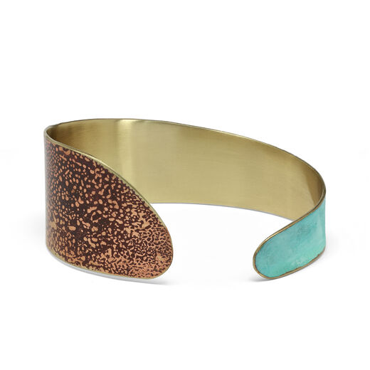 A brass cuff bracelet with a turquoise and brown coloured patina.