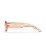 The side of a pair of peach pink sunglasses with a transparent frame.