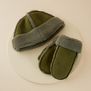 A matching pair of green and grey mittens and winter hat.