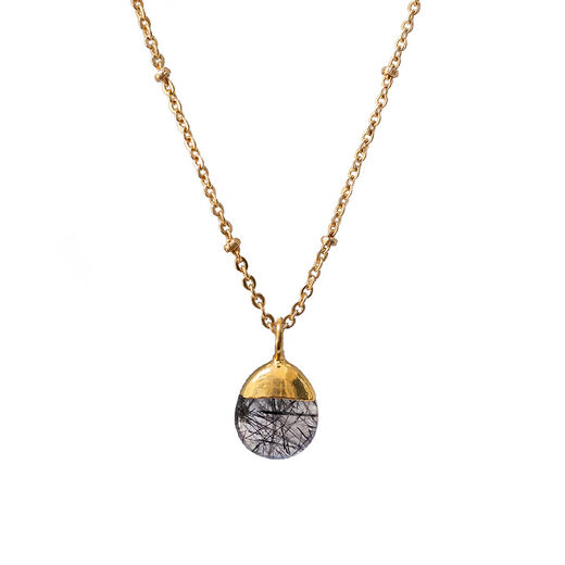 A gold chain necklace with a round shaped black and grey gleaming pendant. 