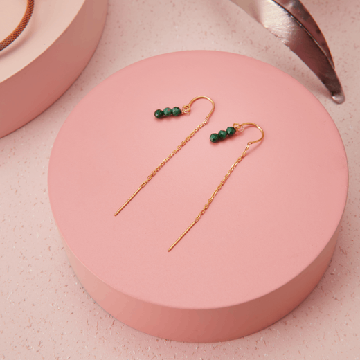 Pull through earrings featuring three green beads on a gold chain