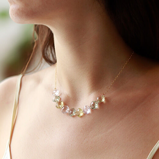 A model wearing a necklace featuring cushion cut stones.