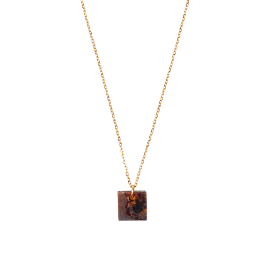 A square necklace pendant in a multicoloured marbled pattern hanging from a thin gold chain.
