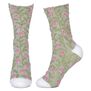 A pair of green socks featuring branches of pink flowers.