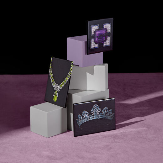Three black magnets featuring Cartier jewels propped up on plinths.