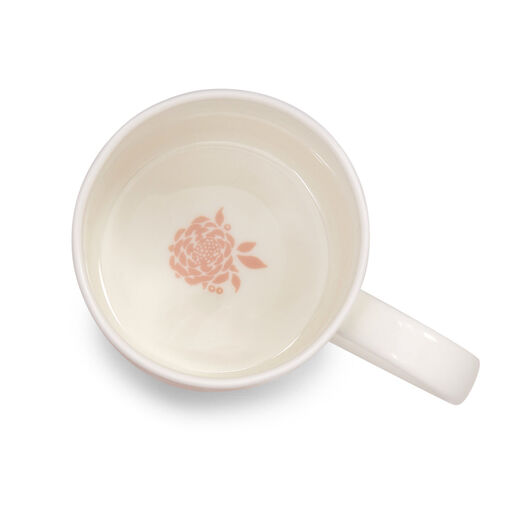 The inside of a white china mug with a pink flower printed at the bottom.