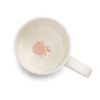 The inside of a white china mug with a pink flower printed at the bottom.