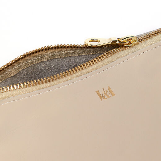 Detail of a beige leather pouch with a gold zip and V&A logo.