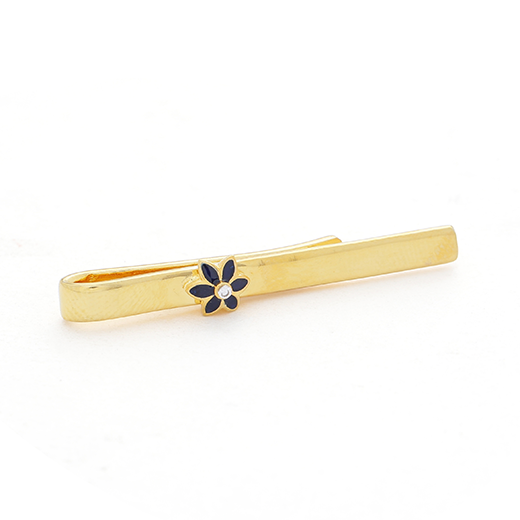 A gold tie pin with a blue flower accent.