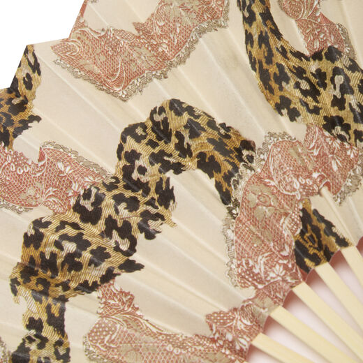 Close up of a paper hand fan featuring a pattern with pink lace and leopard printed ribbons.