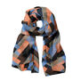 A looped modal scarf featuring an orange, blue and black zigzag Art Deco pattern.