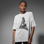 A young black model is posing wearing a white oversized t-shirt. On the chest is printed a black and white photo of a model seated in a leopard printed outfit..