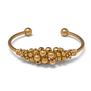 A gold plated cuff bracelet adorned with gold beads.