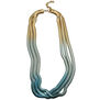 A three strands chain necklace in a gold and blue colour gradient.