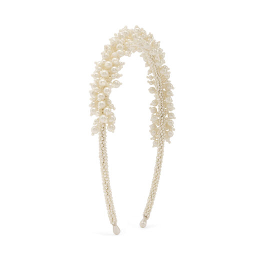 A beaded headband with white faux pearls on a metallic base.