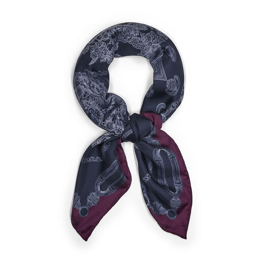 A looped navy blue scarf with a print featuring an intricate illustration of jewellery items.