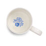 The inside of a white china mug with a blue flower printed at its bottom.