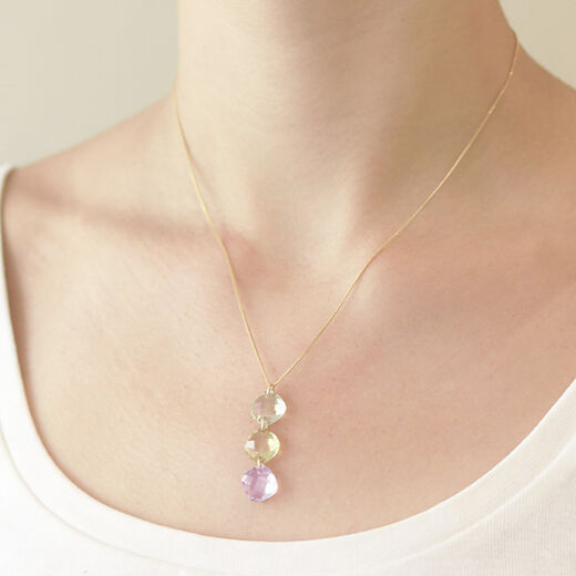 A model wearing a necklace featuring cushion cut stones.