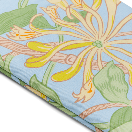 Detail of an oven glove featuring a blue, green and yellow honeysuckle pattern.