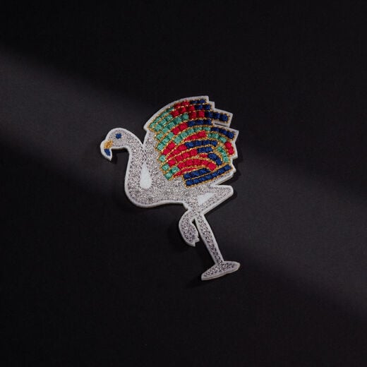 The likeness of a diamond and gemstone Flamingo, sewn in silver, red, green and blue threads 