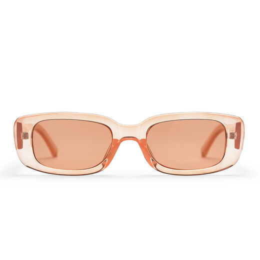 A pair of peach coloured sunglasses with a transparent frame.