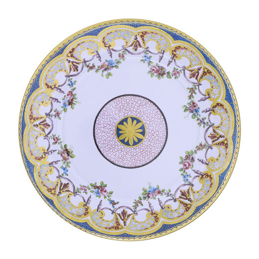 A round plate featuring a pink, lilac and gold pattern inspired by 18th century French porcelain.