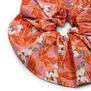 A close up of a cotton scrunchie with a floral pattern.