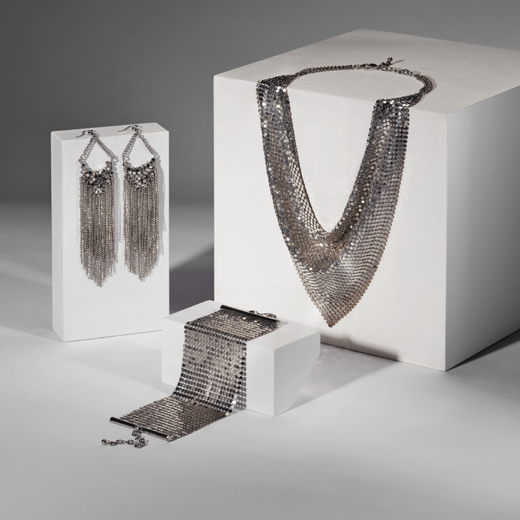 A set of three silver chainmail jewellery comprised of matching bracelet, necklace and earrings.