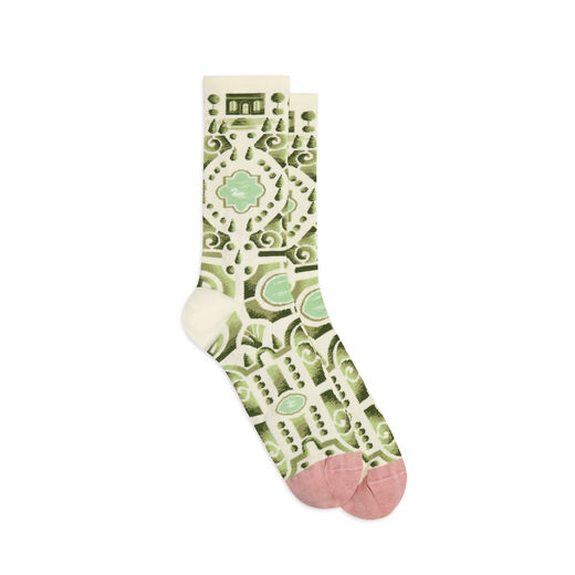 A pair of cotton socks in pastel colours. The pattern features the Versailles gardens in soft green on a cream background, with pastel pink tipped toes.