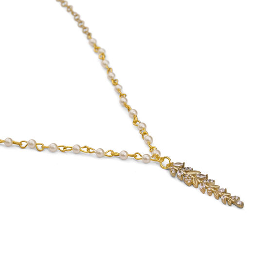 Detail of a pendant in the shape of a long pointy leaf, adorned with clear crystals.