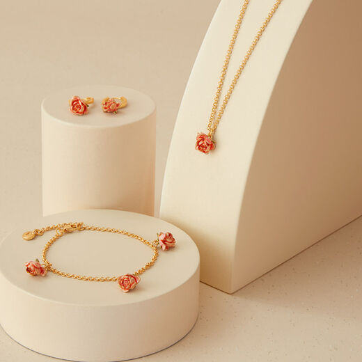 A matching jewellery set consisting of a gold chain necklace, a bracelet and a pair of earrings with rose buds pendants.