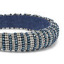 A close up of a statement headband encrusted with silver and blue beads.
