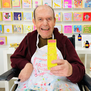 ARTHOUSE Unlimited artist Peter Andrews holding the hand cream box featuring is artwork to the camera.
